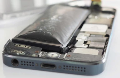 een foto van een smartphone waarbij de accu in de telefoon gezwollen is en meer lijkt op een ballon