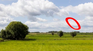 een inelkaar geflanste foto van een grasland met wat bomen en in de lucht een 'zwevende nul' te zien is (letterlijk een nul die zogenaamd zweeft in de lucht. Tja, je moet wat verzinnen om een illustratie bij een artikel te plaatsen