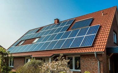 foto een woning waarbij vrijwel het hele dak volgelegd is met zonnepanelen