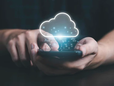 foto van een hand die een mobiel vast houdt waarbij een 'cloud' te zien is waar de app gebruik van maakt